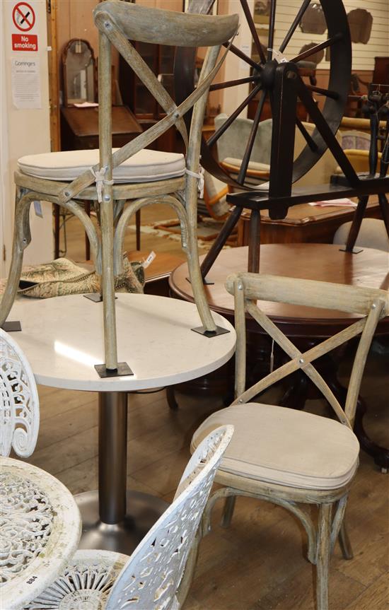 A white quartz circular topped table on stainless steel pillar and platform base and a pair of bentwood X back chairs
